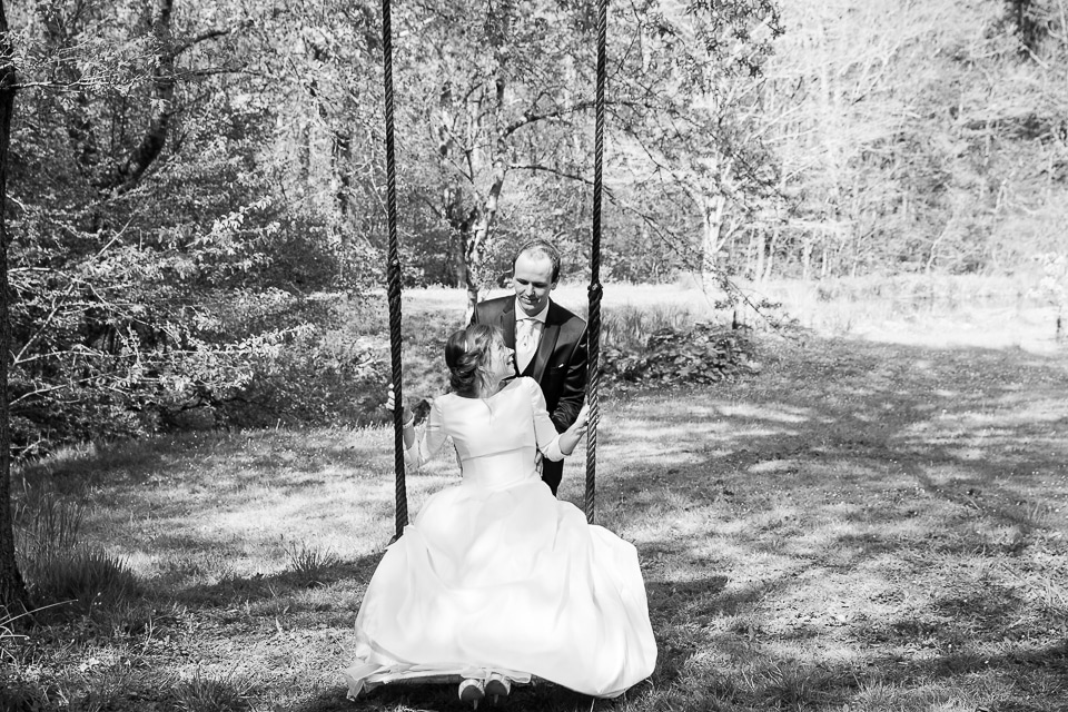 mariés faisant de la balançoire lors d'une séance photo